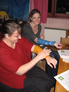 Deux participantes à la soirée, occupées à placer correctement une compresse destinée à faire baisser la fièvre.